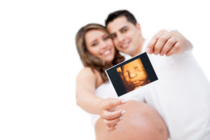 Happy pregnant couple showing the ultrasound of her baby!